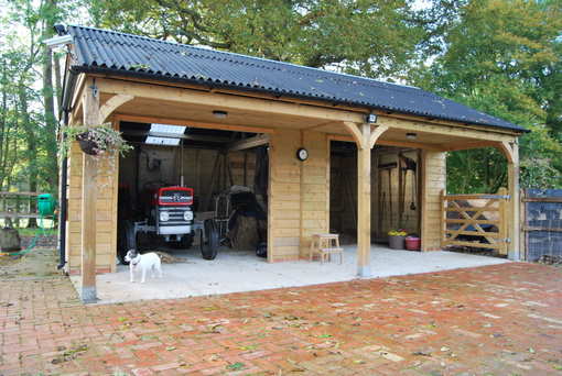 An image of a wooden carport with a tractor parked inside.