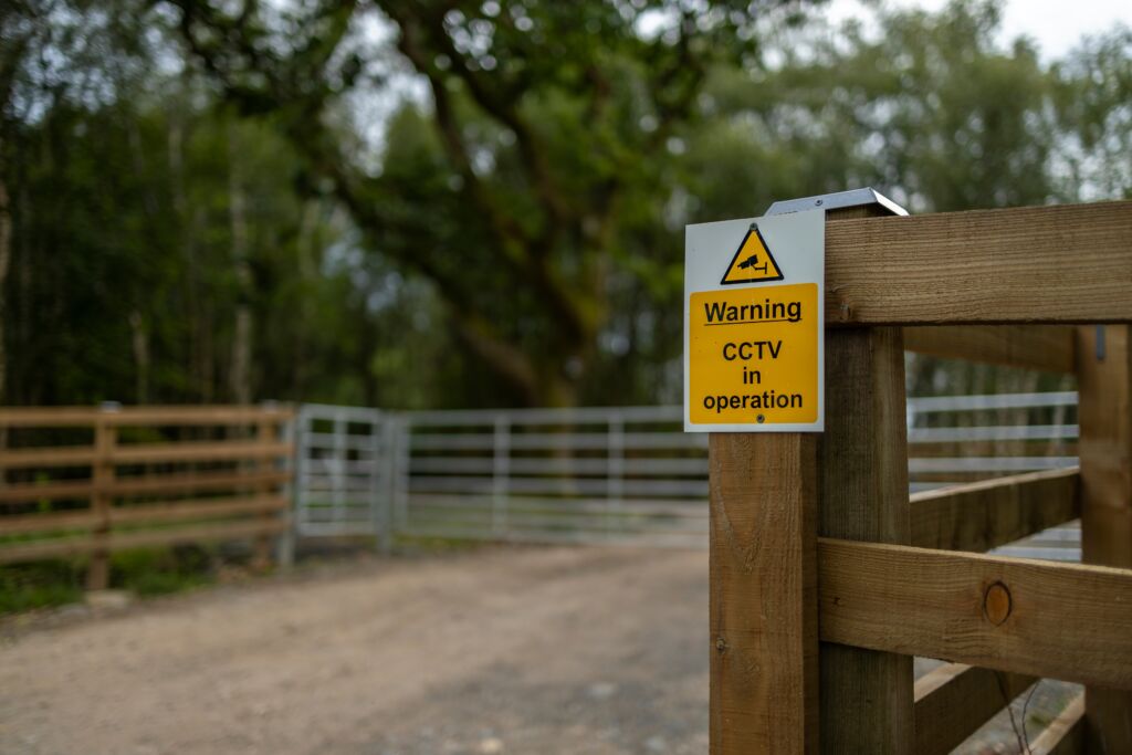 A farm with a CCTV warning sign.
